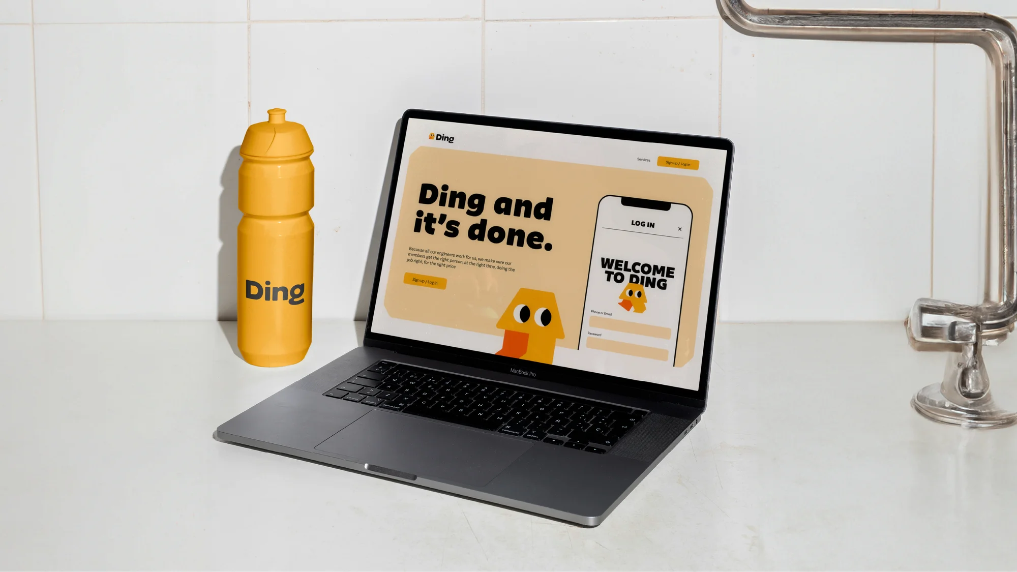 Laptop displays 'Ding' website next to water bottle in a clean kitchen setting, promoting a digital platform and healthy lifestyle.