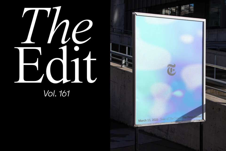 A New York Times advertisement, 'The Edit Vol. 161', is displayed on a public sign with blue and lavender background with Times logo.