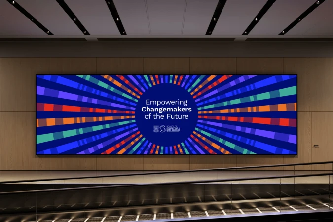 Eye-level indoor shot of a colorful display that reads 'Empowering Changemakers of the Future' with a school of data science logo.