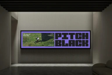 A wide framed wall display featuring a purple brand identity banner with bold black typography reading Pitch Black.