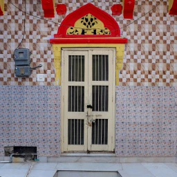 Beige barred double doors with bright red and yellow decorative lintel set against patterned tiled walls for Curry Cafe brand identity