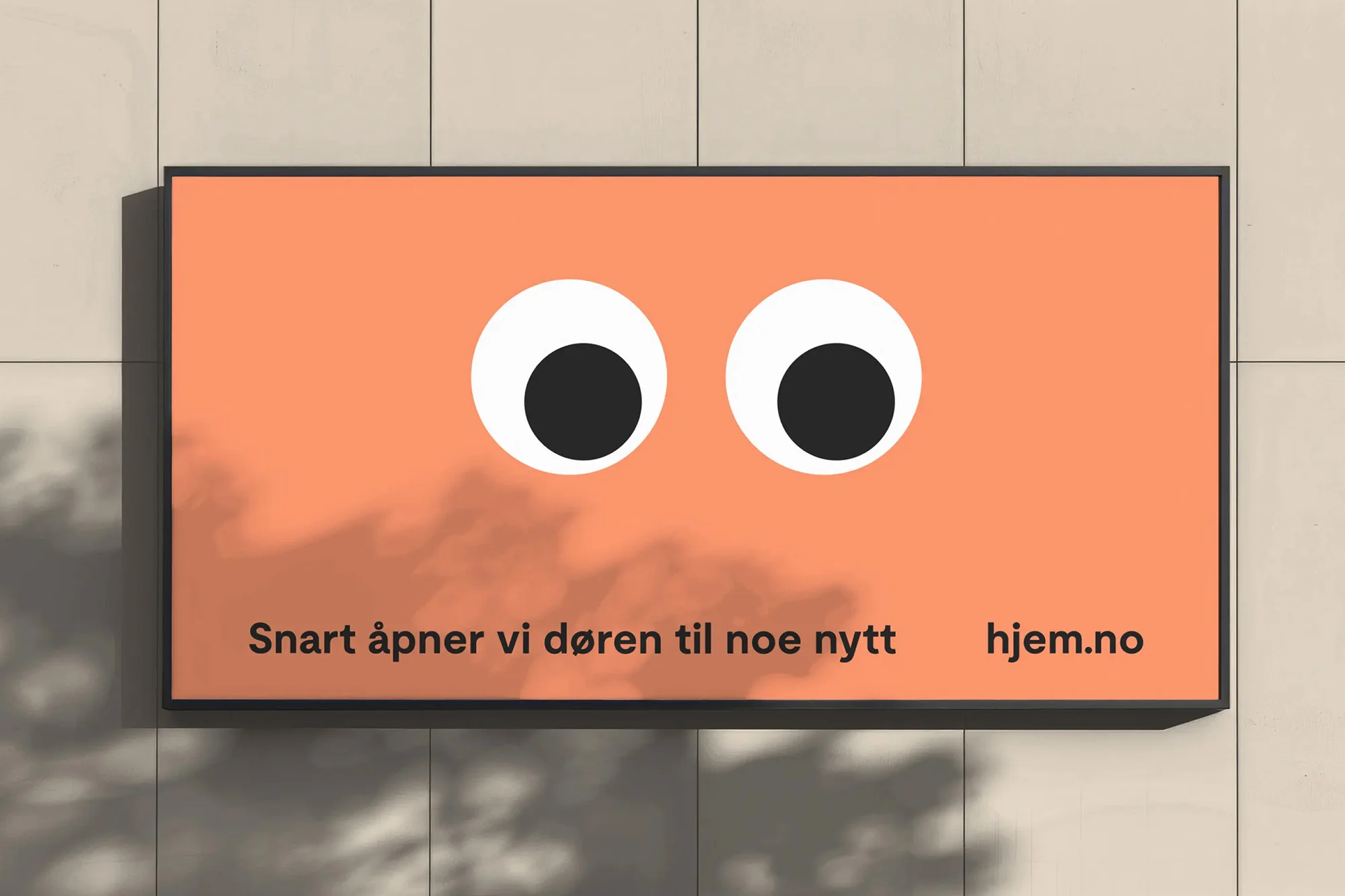 Billboard advertisement featuring oversized googly eyes on an orange background, set against a textured wall with soft shadows.