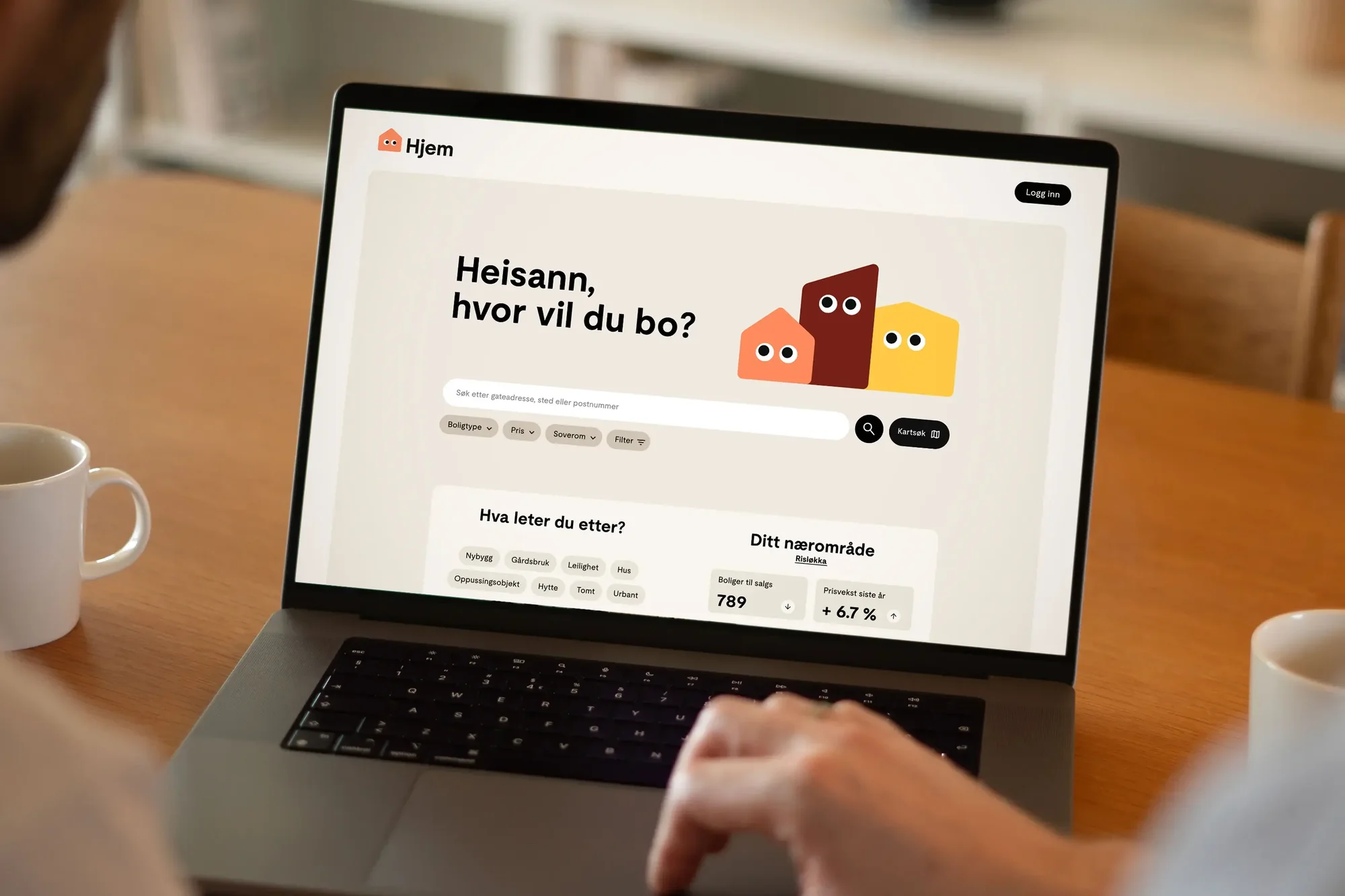 Person using a laptop displaying a real estate website with cartoon house icons. The screen displays search options and Norwegian text.