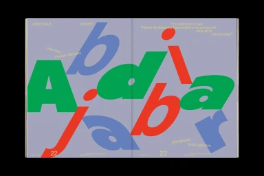 Spread design featuring oversized stylized typography in blue, green, and red against a lavender background