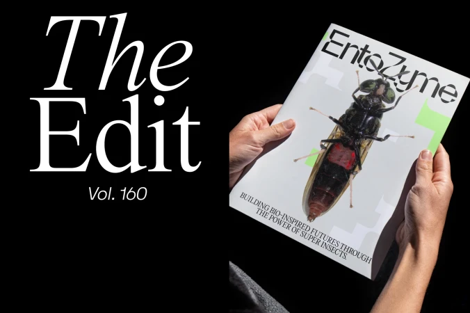 Close-up of hands holding a magazine titled EntoZyme featuring an insect on the cover next to large white text on a black background.