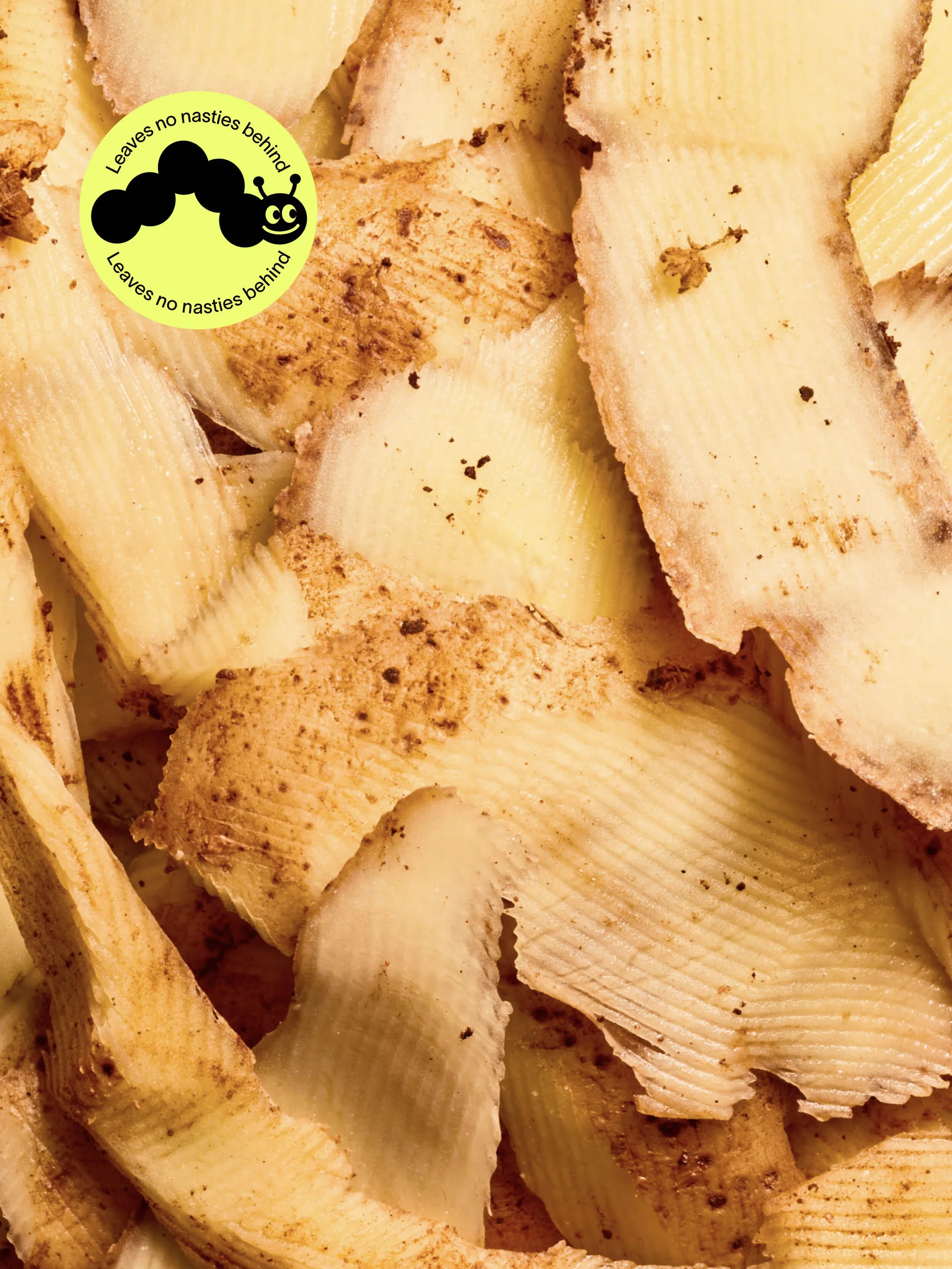 Close-up of pile of potato peels featuring ridged texture, neutral tones, and a logo promoting natural ingredients, emphasizing food waste.