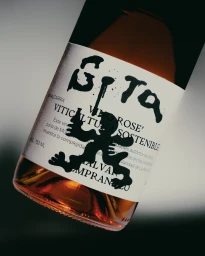 Close-up shot of a Gota wine bottle with a distinctive white label and dark typography against a neutral background.
