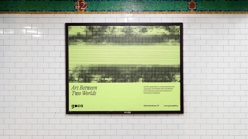 Framed GoCA gallery art exhibition poster on a subway station wall with a green and black design, promoting an art exhibition.
