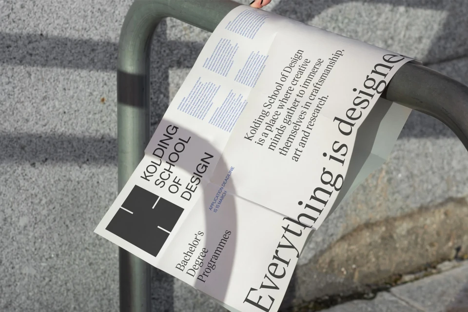 Kolding School of Design advertisement poster attached to a metal railing with an application deadline of March 15th.