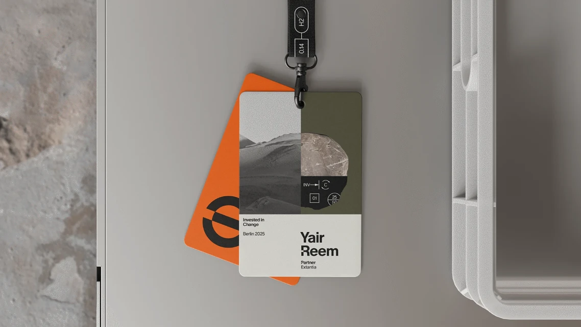 Two identity cards hanging with branded lanyards, one orange with a logo, and the other with desert and mineral imagery.