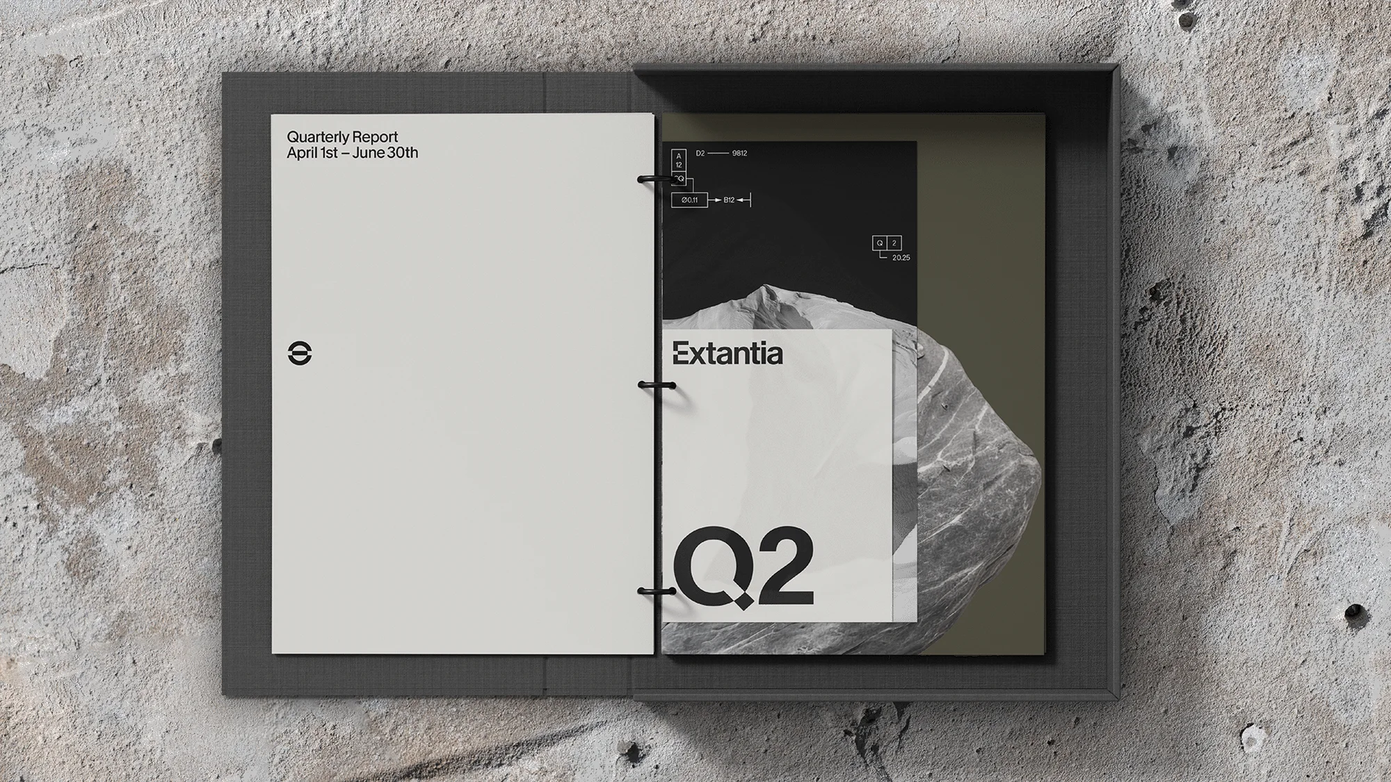 Open report binder lying on textured concrete surface, featuring quarterly report and Extantia brand document design layouts.