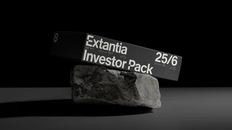 Black Extantia Investor Pack box balanced on a rough grey rock against a dark studio backdrop