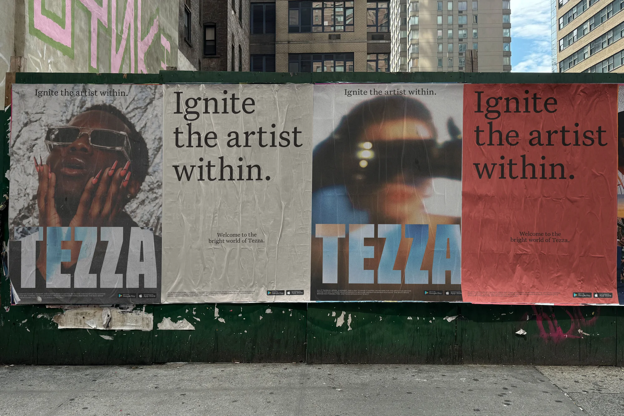 Four wheatpaste posters affixed to a green urban construction fence featuring the Tezza brand identity and text Ignite the artist within.