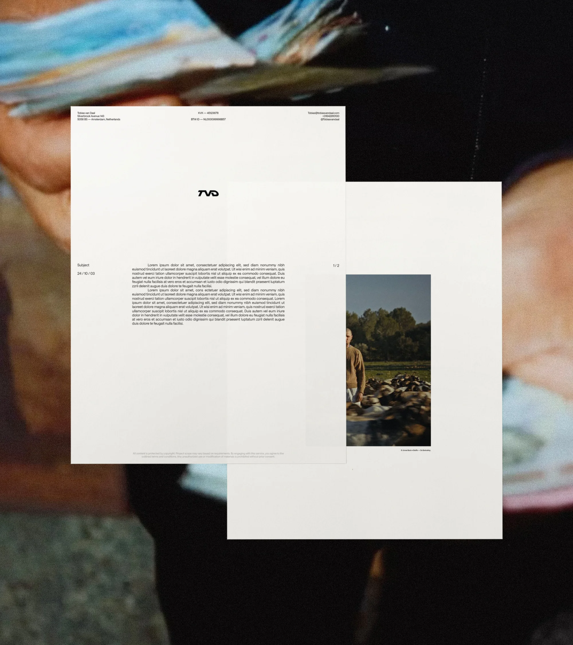 Abstract image featuring stacked white paper sheets with graphic designs, text, and photography elements in a blurred background.