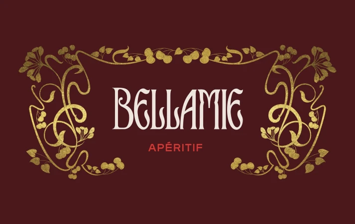 Elegant gold floral design framing BELLAMIE and APÉRITIF text on a rich burgundy background in a visually appealing composition.