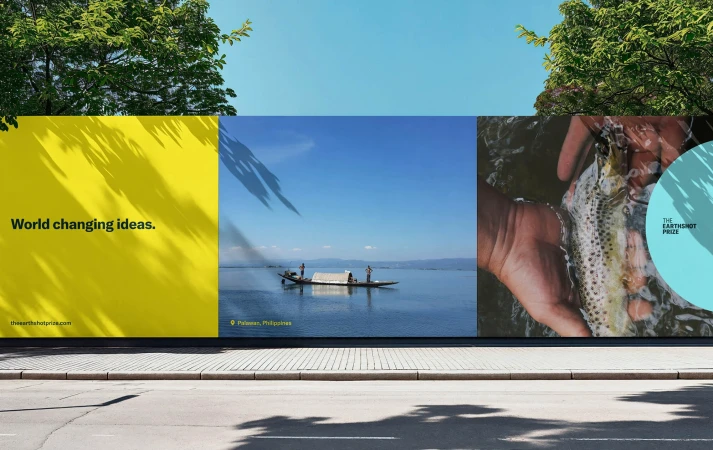 Outdoor billboard featuring scenic images: a yellow panel with text, a boat on a lake, and hands holding a fish in water.