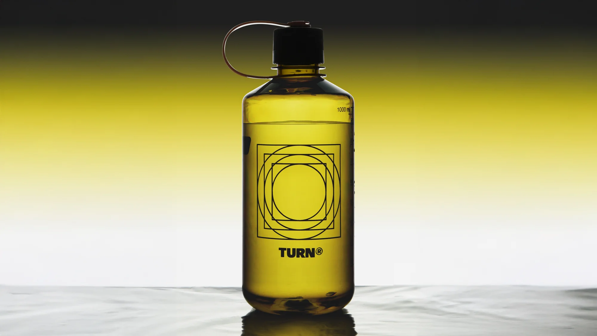 Water bottle filled with yellow liquid. Clear plastic with black lid, geometric logo design. Studio shot with light background.