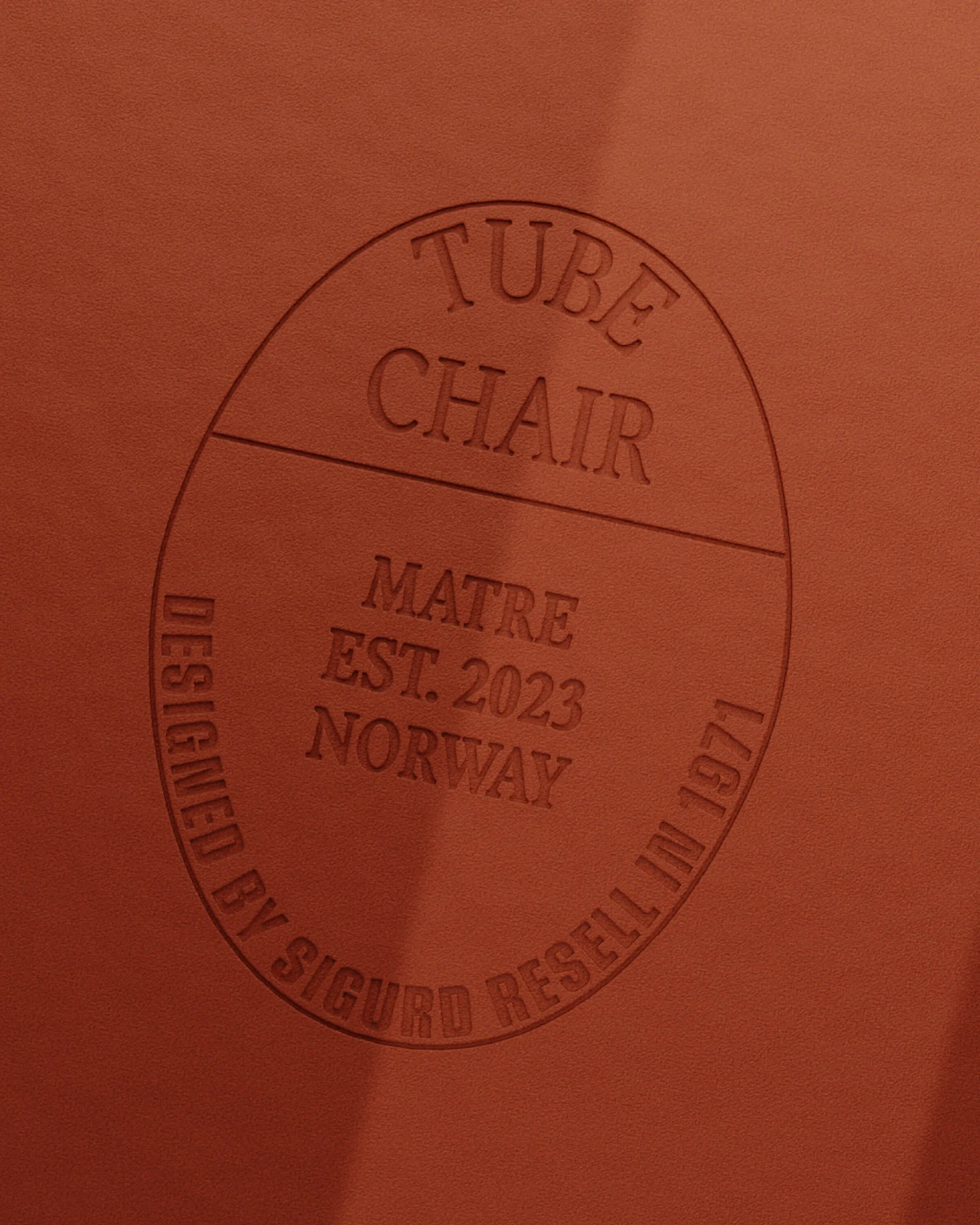 Close-up of a chair with a circular stamp featuring 'Tube Chair', 'Matre', 'Est. 2023 Norway', and 'Designed by Sigurd Resell in 1971'.