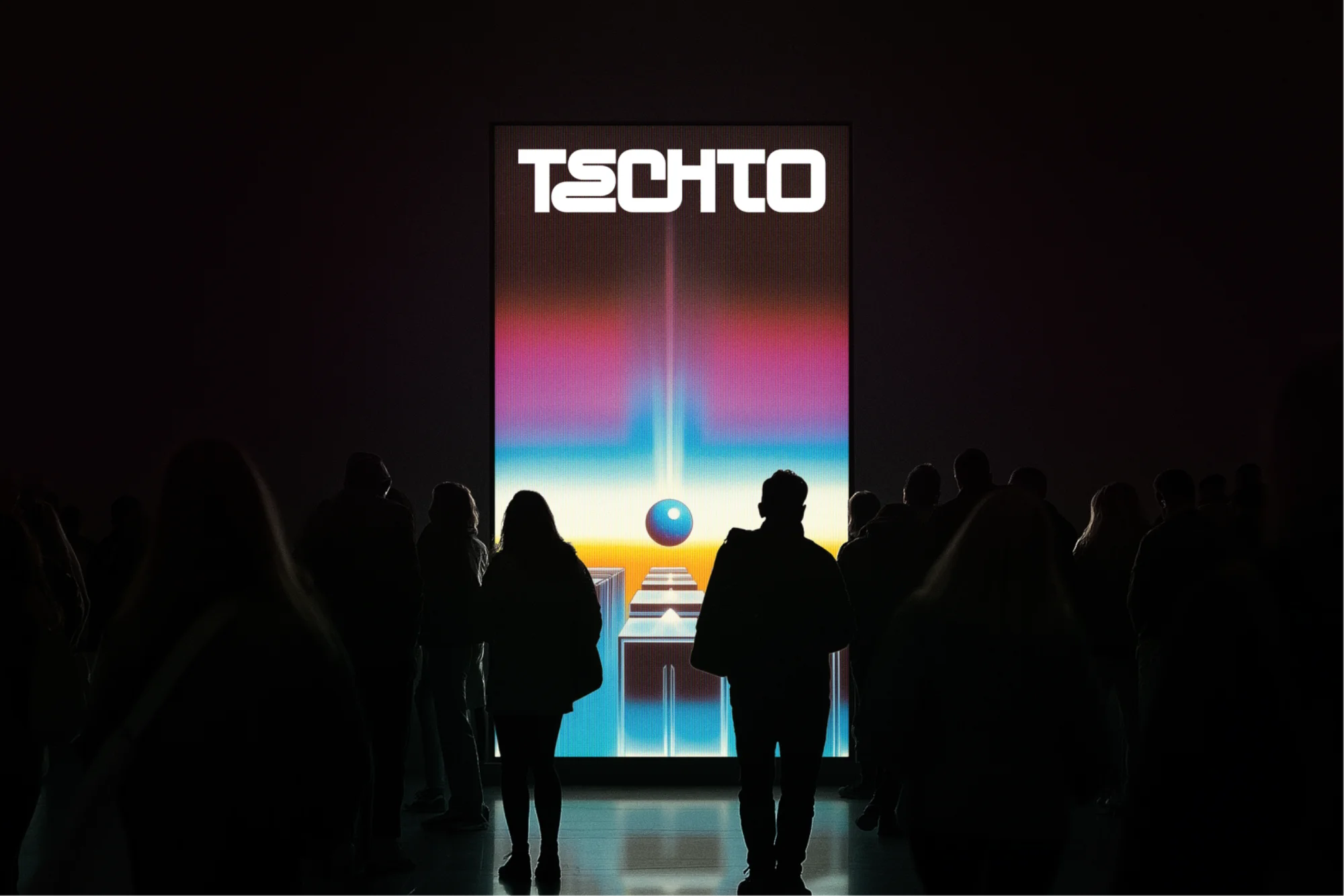 Silhouetted crowd of people viewing a digital art display with colorful geometric graphics, text, and a glowing sphere in a dark room.