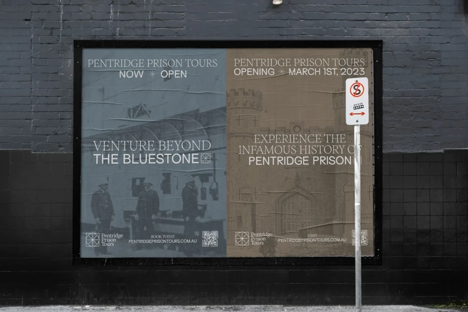 Outdoor advert for Pentridge Prison Tours shows images of the prison's interior and exterior on a dark gray brick wall.