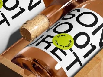Close-up product shot of Maison Fleuret wine bottles inside a wooden presentation box with white labels and bold typography.