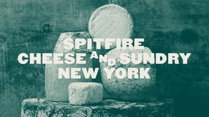 A stack of five differently shaped cheeses, with the words Spitfire Cheese And Sundry New York printed across the image in white text.