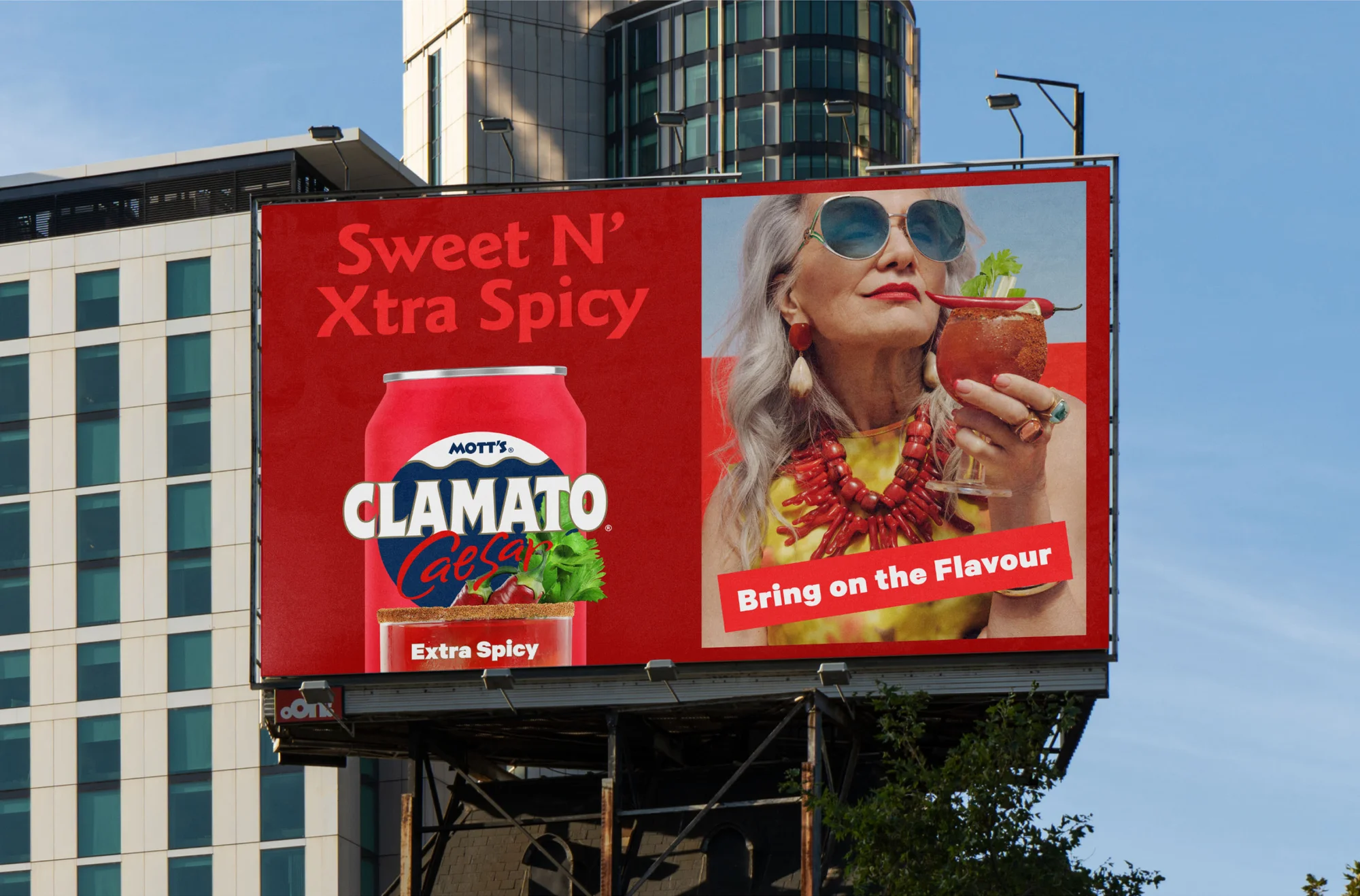 Billboard ad for Mott's Clamato Caesar featuring a can, the drink in a glass, and an older woman with sunglasses and a yellow shirt.