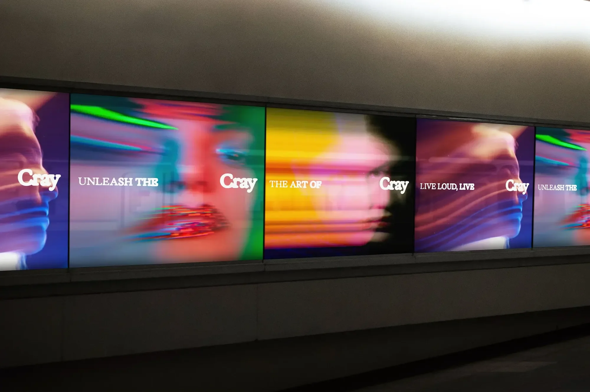 Series of blurred motion-graphic posters with text "Cray", portraits, and vibrant colors; viewed indoors.