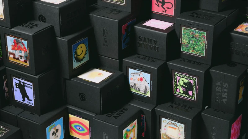 Collection of black boxes with artistic graphics and text labels stacked in an organized manner, creating a visually interesting pattern.