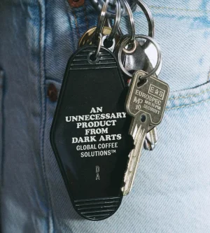 Black hotel-style keychain fob and metal keys attached to light blue denim jeans