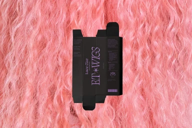 Black product box with purple branding for E.T WIGS lace glue laid over textured pink wig hair