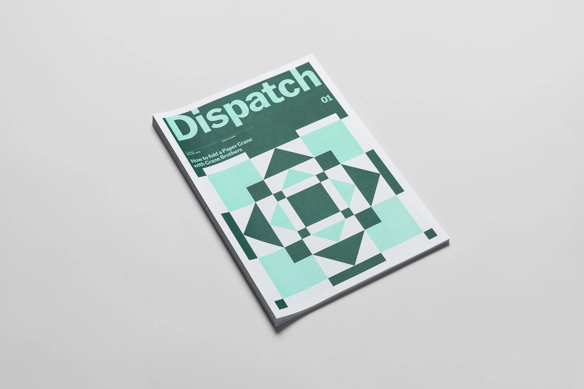 Close-up of a 'Dispatch' magazine featuring geometric teal and green patterns, clean typography, and a modern aesthetic.