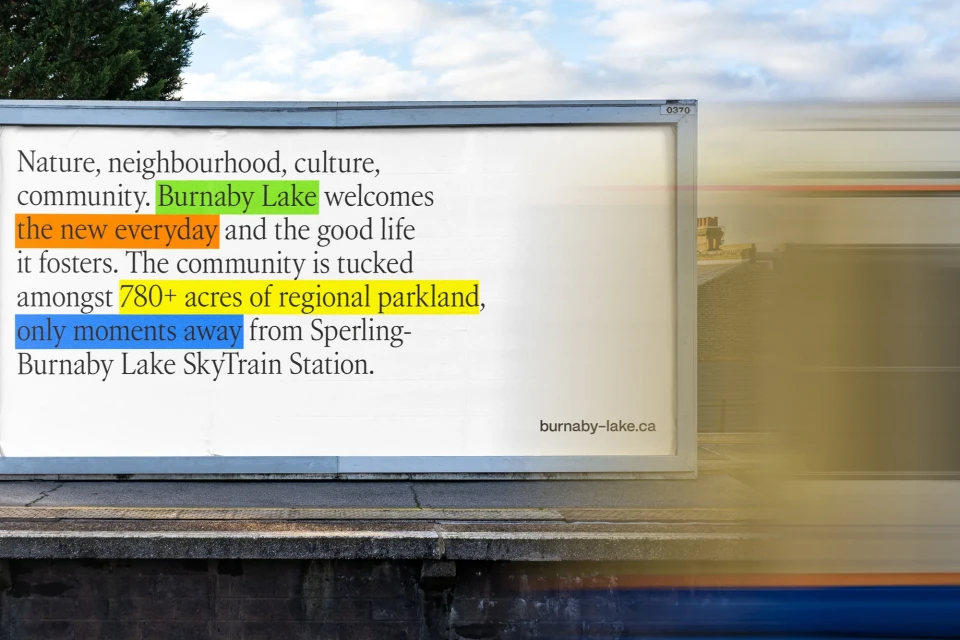 Billboard advertisement featuring text about Burnaby Lake, regional parkland, and proximity to SkyTrain station against a cloudy sky.