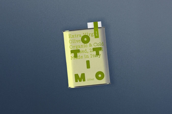 Olive oil tin can on a textured blue surface with a simple label design featuring green text. The can has a minimalist aesthetic.