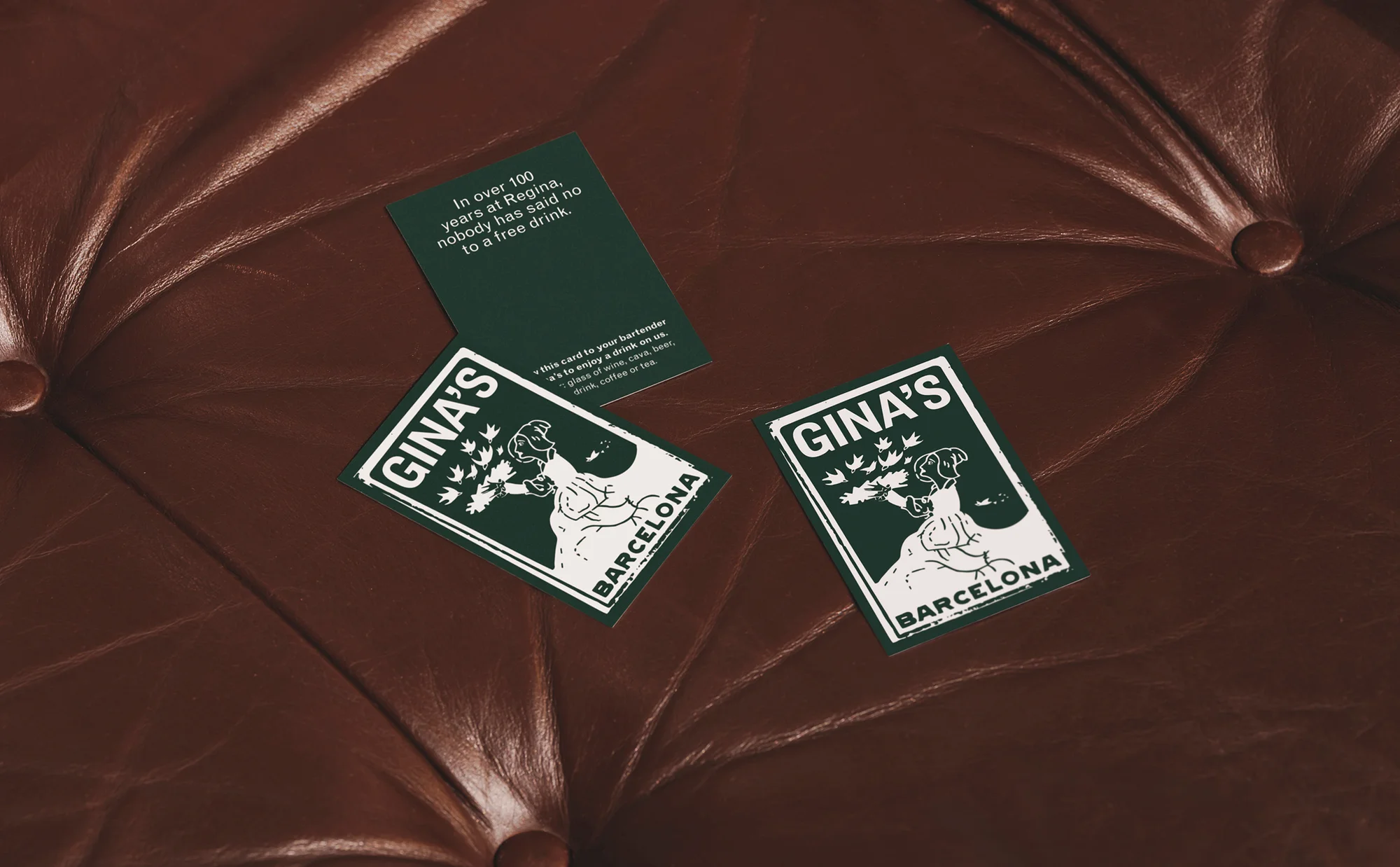 Close-up of Gina's Barcelona cards on a brown leather surface, highlighting the card design and texture of the leather.