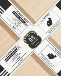 Close-up overhead shot of branded product packaging featuring black and white typographic labels on brown paper.