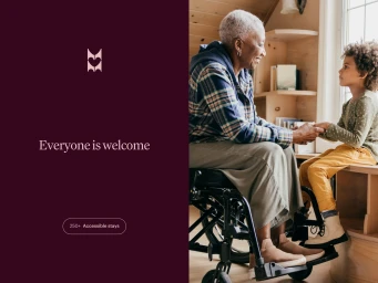 An elderly Black woman in a wheelchair interacting with a young child indoors near a window.