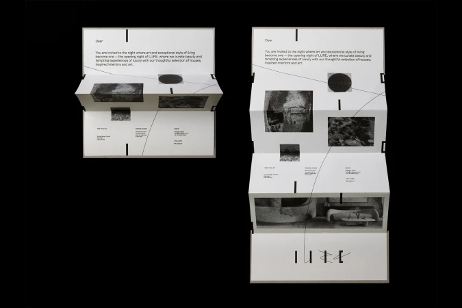 Open printed accordion brochure with black and white imagery, typography, and folded panels against a dark background