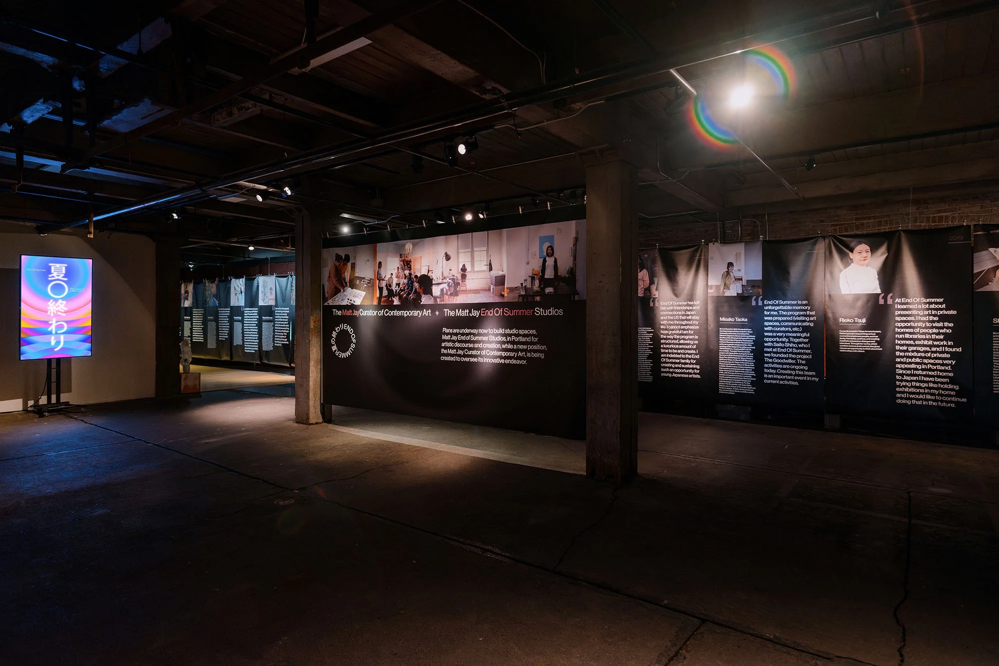 Contemporary art exhibition in a gallery featuring poster displays with text and images, creating an immersive visual experience for visitors.