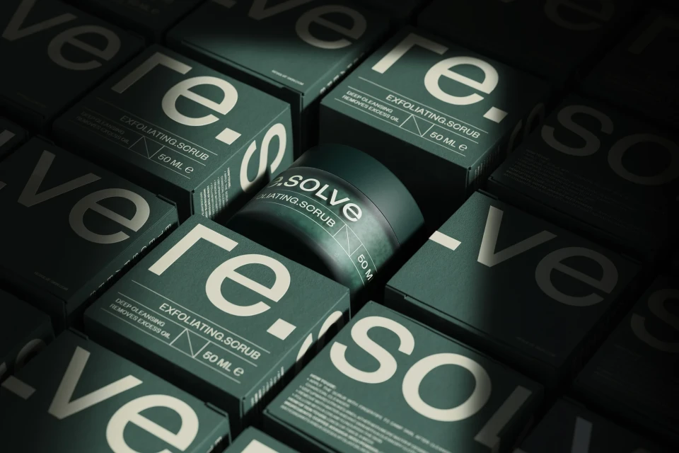 Close-up studio shot of Re.Solve exfoliating scrub jar and packaging, featuring deep green hues and crisp, modern typography.