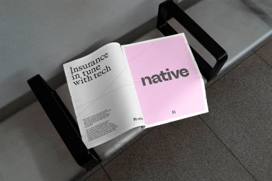 An open magazine displaying the Native brand identity with typography on a bench