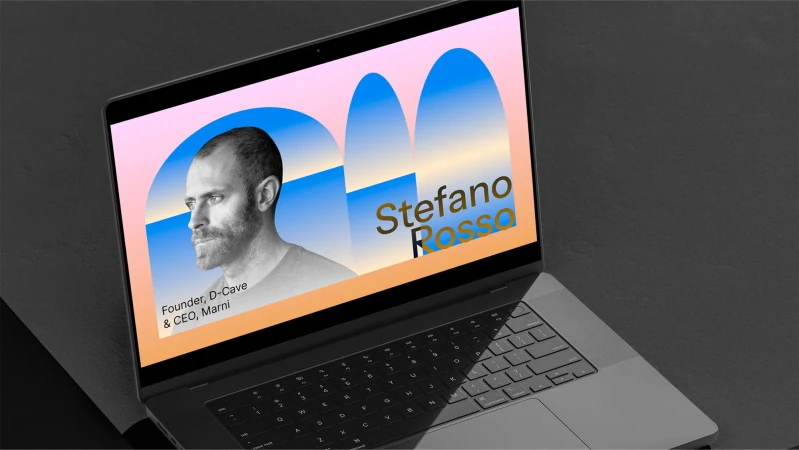 Laptop screen displays Stefano Rosso's monochrome portrait, name in gold, and company details against geometric shapes in peach and blue tones.