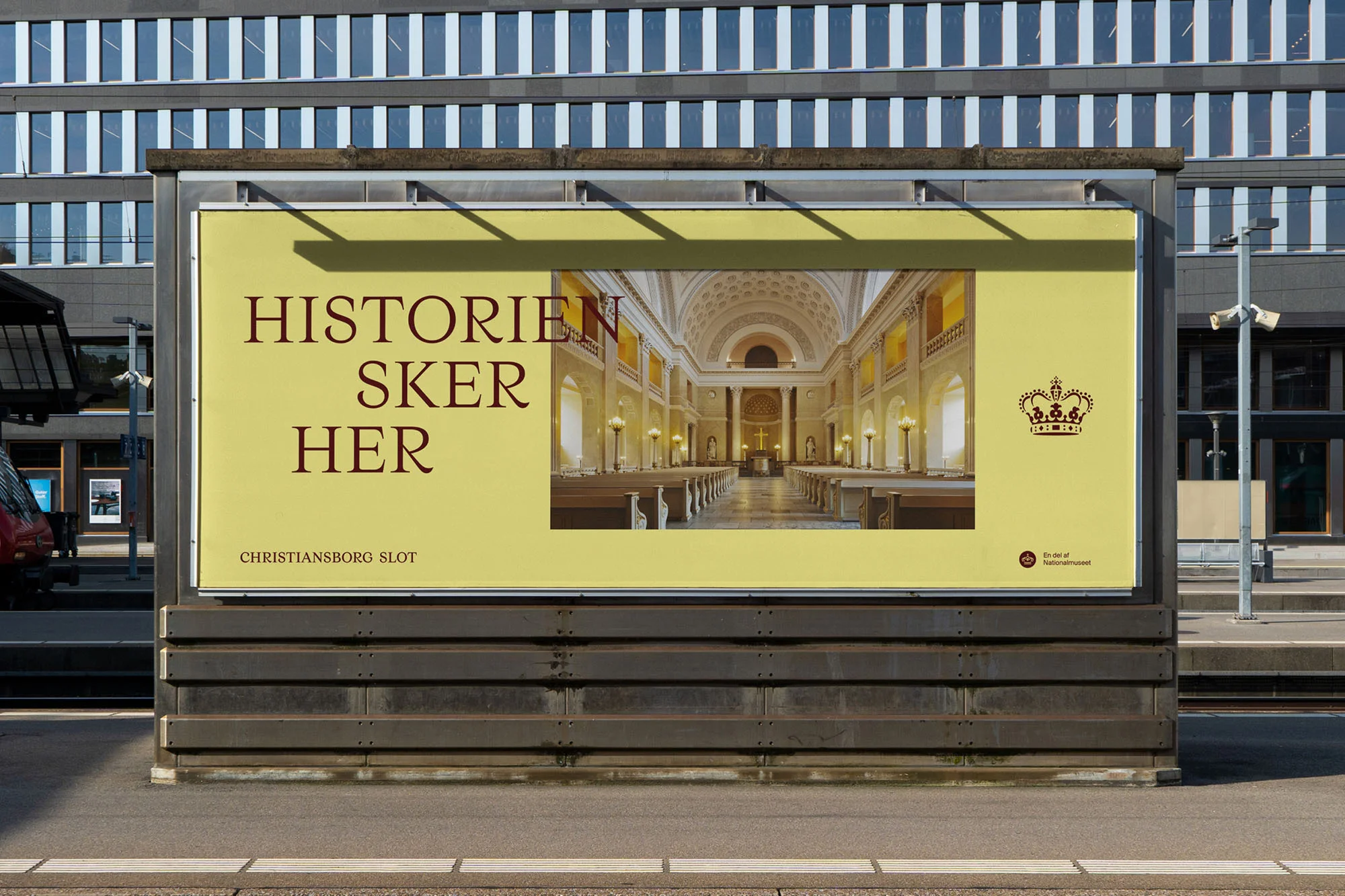 Billboard advertisement for Christiansborg Slot featuring an interior view of a chapel, located on a city street with a modern building in background.