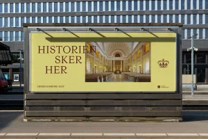 Large yellow outdoor advertising billboard featuring typography and a palatial interior photo mounted outdoors.
