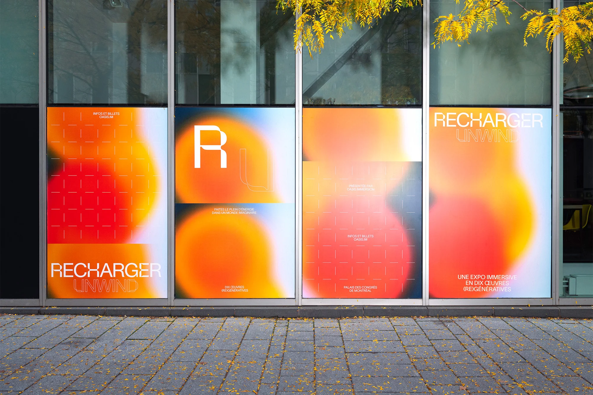 Outdoor view of four vibrant exhibition posters, featuring blurred orange and white graphics and bold typography, displayed on a building facade.