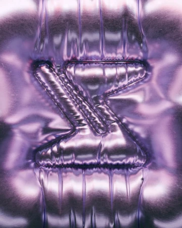 Abstract image with metallic silver and purple tones, featuring an embossed or inflated stylized letter Z on a shiny, rippled surface.