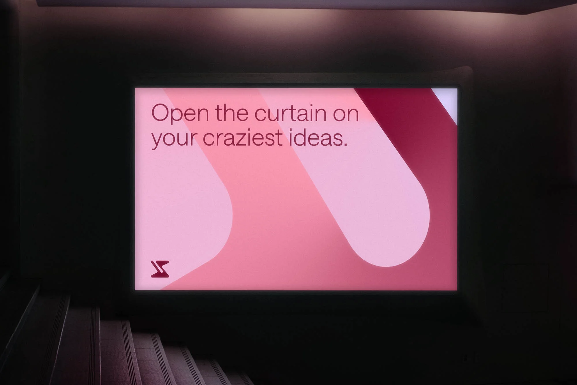 Illuminated sign in a dark hallway with the text: Open the curtain on your craziest ideas, and a graphic design element on the side.