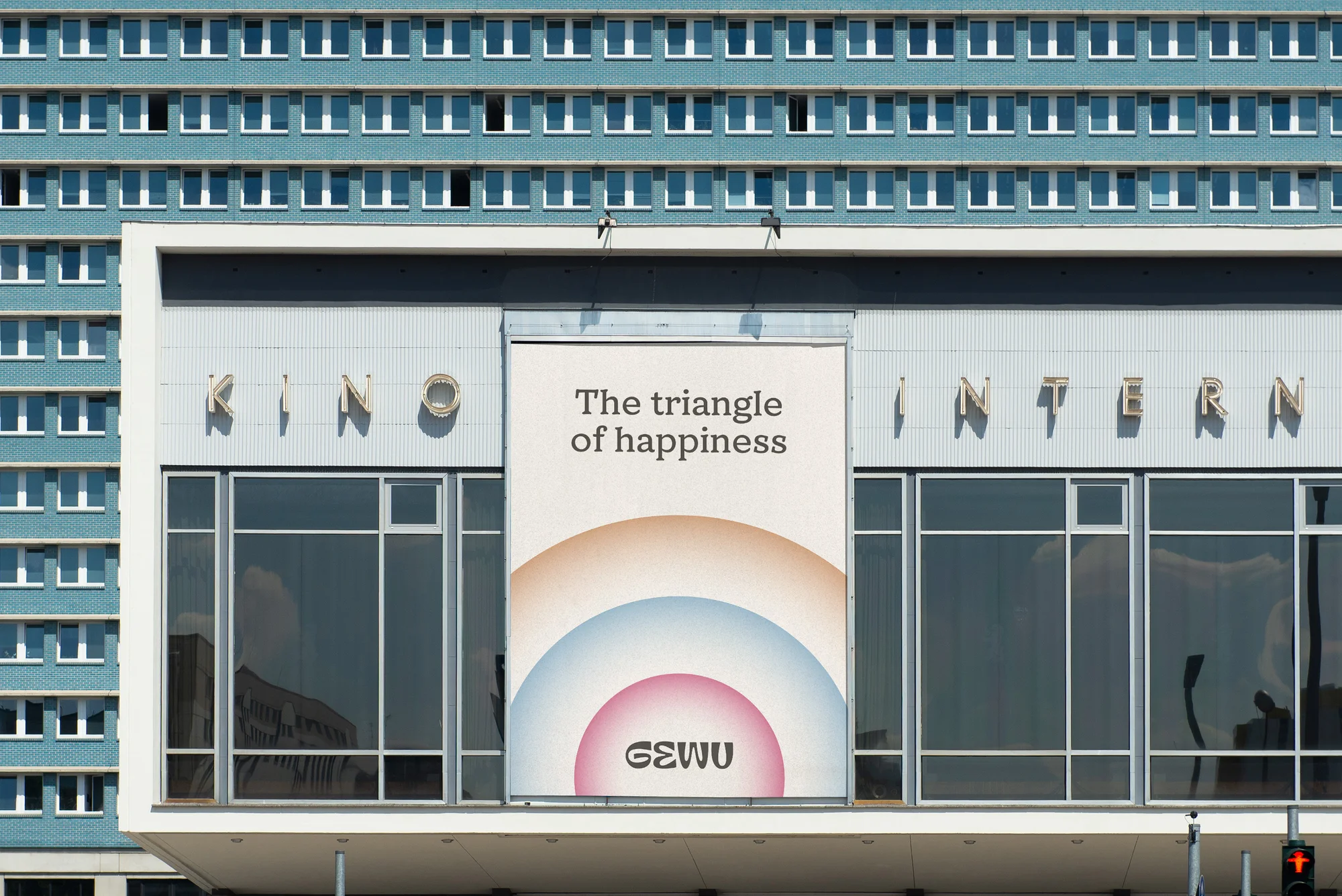 Facade of Kino International, a cinema in Berlin, Germany, featuring a poster for 'The Triangle of Happiness' movie.