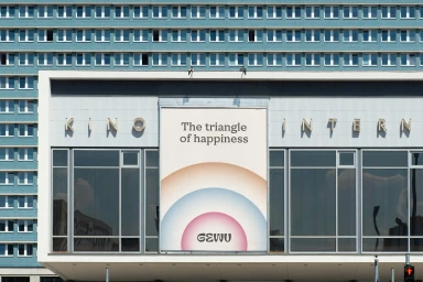 Billboard displaying the Gewu brand identity featuring a triangle of happiness design on a building exterior