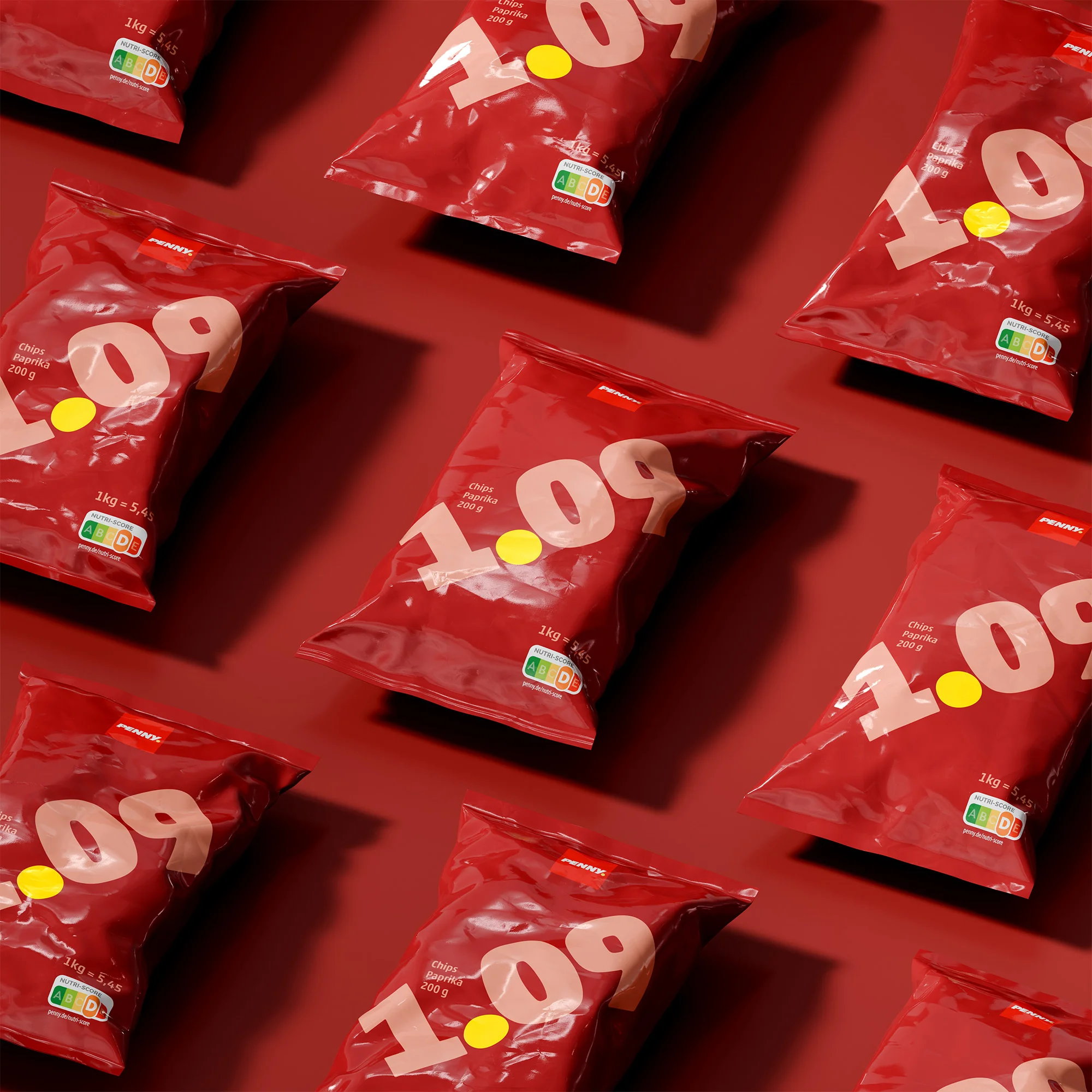 Overhead shot of multiple red bags of chips, featuring a yellow price tag, arranged in a repeating pattern on a red background.